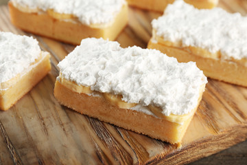 Wooden board with pieces of tasty banana cake, closeup