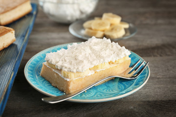 Plate with tasty banana cake on wooden table