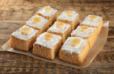 Pieces of tasty banana cake on wooden background