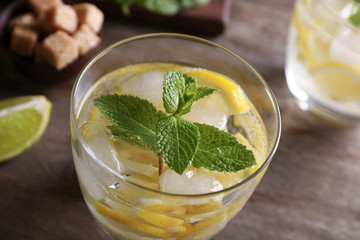 Glass of cocktail with lemon and mint on wooden table