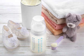 Fototapeta na wymiar Composition with feeding bottle of baby milk formula on wooden table
