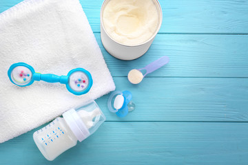 Composition with feeding bottle of baby milk formula on wooden table