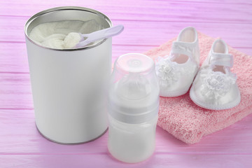 Composition with feeding bottle of baby milk formula on wooden table