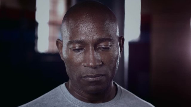  Close up on face of determined male athlete at the gym. Slow motion.