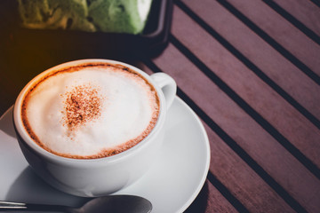 a cup of coffee on the  brown wood table.