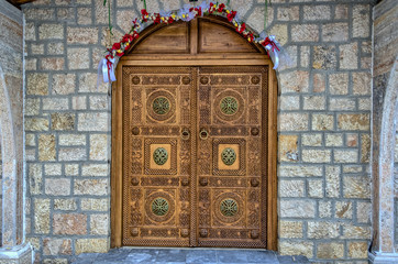 Very Ornate Engraved Wooden Brown Door of Eastern Orthodox Church / Chapel with Arch and Brass Embellishments