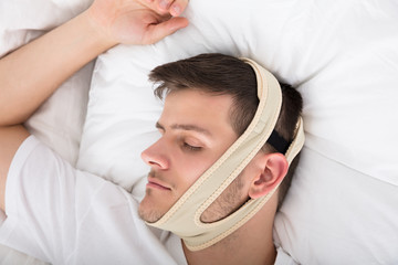 Man Sleeping With Anti Snoring Bandage