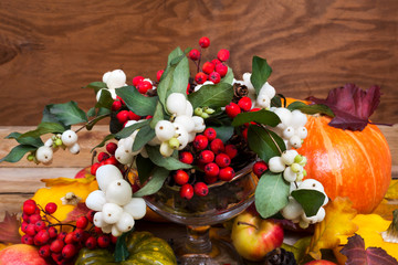 Fototapeta na wymiar Thanksgiving snowberry, rowan berries, pumpkin, apples table centerpiece