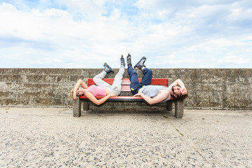 Young tired people friends relaxing on bench.