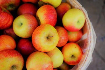 Fresh red and yellow apples in barrels at the farmers market in the fall