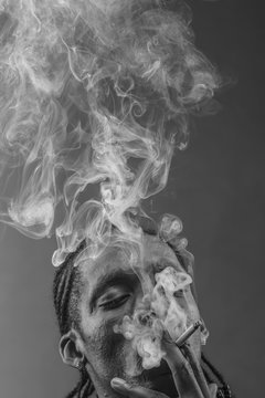 black man smokes a cigarette, thick smoke