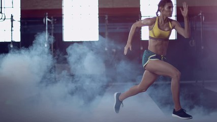 Strong athletic woman running and working out in urban gym