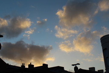 Blue Sky and Clouds with Rooftop Silhouette