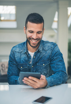 Man Sitting in the Office and Browsing on a Computer Tablet
