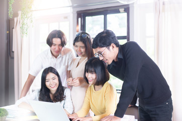 Group of young asian student checking exam results with labtop in classroom