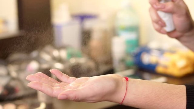 Close-up of a girl squirting on hand disinfectant solution, slow motion. Close-up spraying disinfectant liquid on the hands ,slow motion.