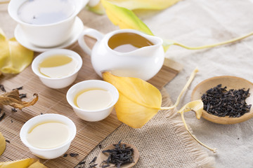 White tea cups and autumn leaves on the table. Autumn tea.
