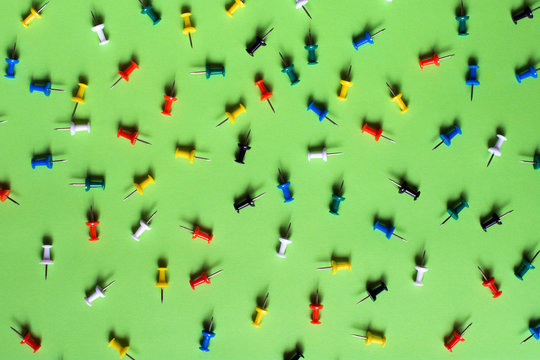 Colorful pins on green background