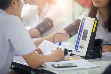 Doctor taking blood pressure against white background