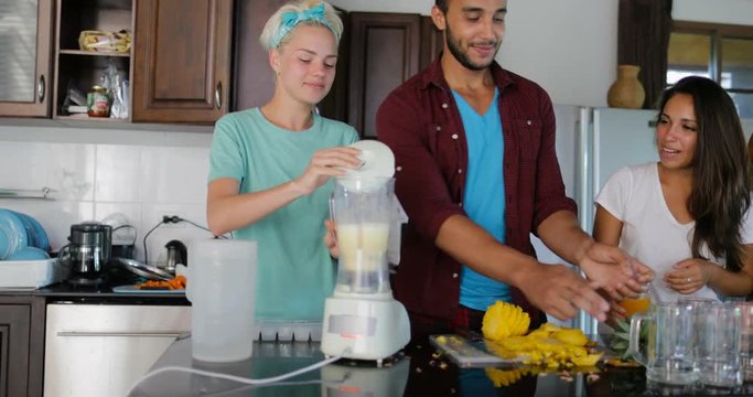 Young Man And Woman Use Blender Prepare Healthy Smoothie Pour It In Glasses People Group Talking Two Couples In Kitchen Cooking Together Slow Motion 60 - Powered by Adobe