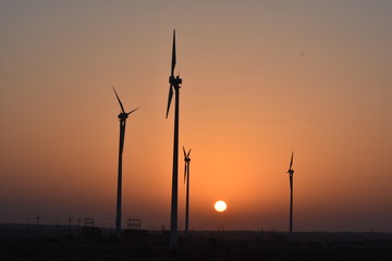 Obraz premium sunrise with modern wind mills in great thar desert jaisalmer rajasthan india