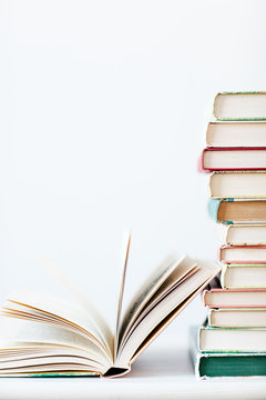 An open book next to a stack of books