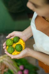 A massage therapist holding a bold of herb for spa