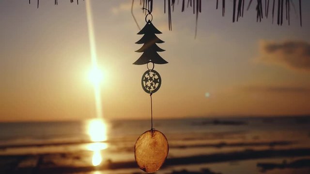 Small Christmas tree hangs on the beach with sunset view to the ocean in slow motion. Koh Samui. Thailand. 1920x1080
