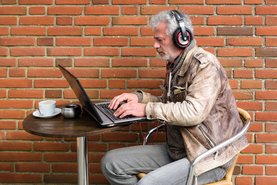Geschäftsmann arbeitet am Laptop in einem Straßencafé