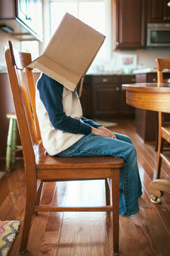 grumpy boy with a box over his head