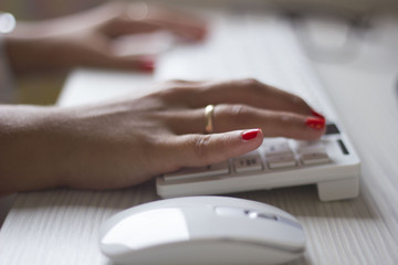 Fototapeta premium Female hands typing on white computer keyboard