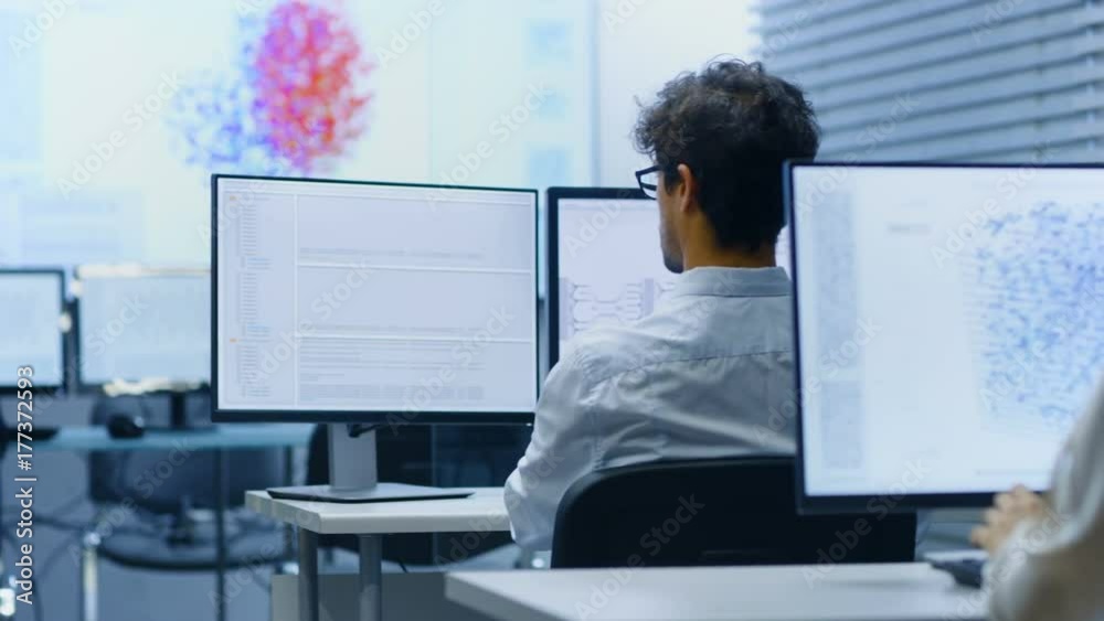 Poster Multi-Ethnic Team of International Computer Scientists Develop Neural Network at Their Workstation. Office is Full of Displays with Functioning AI and Neural Data Infographics.
