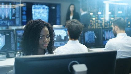 Female Computer Engineer Works on a Neural Network/ Artificial Intelligence Project with Her Multi-Ethnic Team of Specialist. Office Has Multiple Screens Showing 3D Visualization. - Powered by Adobe