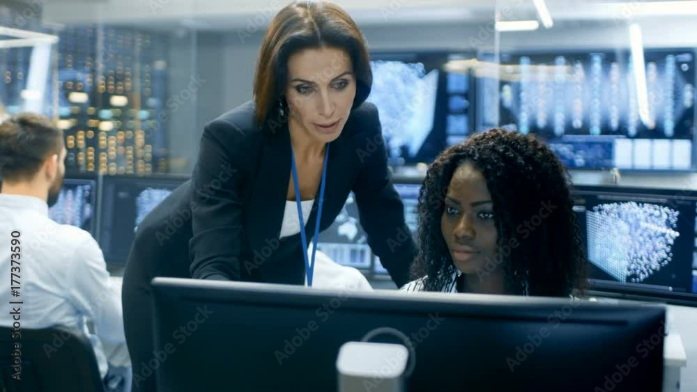 Aufkleber Female Team Leader Consults Young Neural Network Architect. They Work in a Crowded Office on a Neural Network/ Artificial Intelligence Project. Office Space Has Data Server.