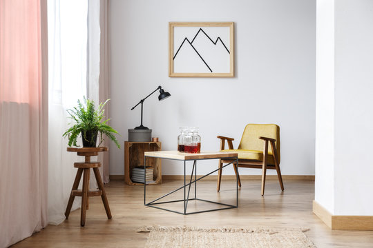 End table, an armchair and a picture above