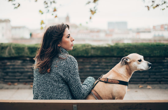 Woman sitting on a bench with her dog
