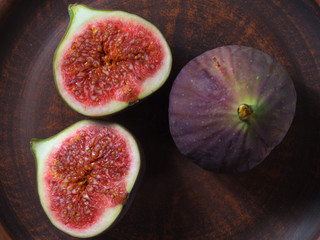 One whole and cut figs in a bowl of clay.