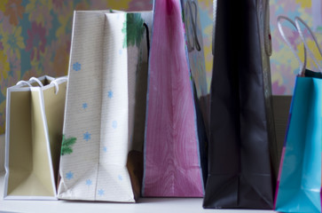 Colorful paper bags on light blurred background