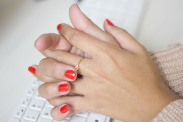 Female hands typing on white computer keyboard