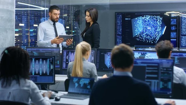 Head of the Department and Project Manager Discuss Work Process Using Data on Tablet Computer. Multi-Ethnic Team Builds Neural Network with Integrated Machine Learning.