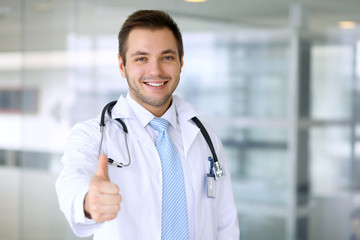 Smiling male doctor with thumb up 