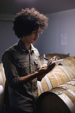 Mix race man writing sample profiles of whisky wine