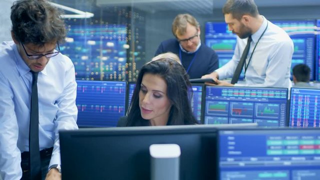 Multi-Ethnic Team of Stock Traders at the Stock Exchange Firm Office is Busy Selling and Buying Bonds and Shares. Displays Show Relevant Graphs and Numbers.