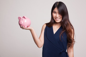 Young Asian woman with a pig coin bank.