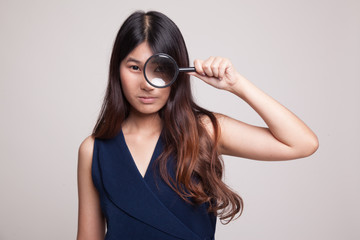 Young Asian woman with a magnifying glass.