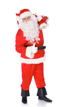 Santa Claus carrying big bag and showing thumbs up or ok isolated on white background. Full length portrait