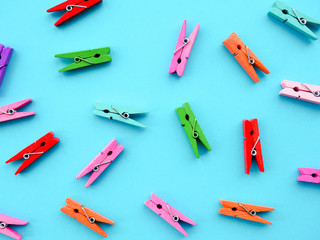 many colored clothespins on a blue background, as a substrate, pin; clothes peg