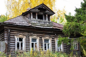 Facade of a traditional Russian house made of wooden logs (izba) with a balcony in autumn. Gorokhovets, Vladimir oblast, Russia