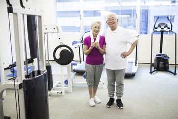 An elderly couple exercising at a training gym