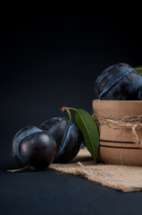 Garden plums in bowl on stone table.
